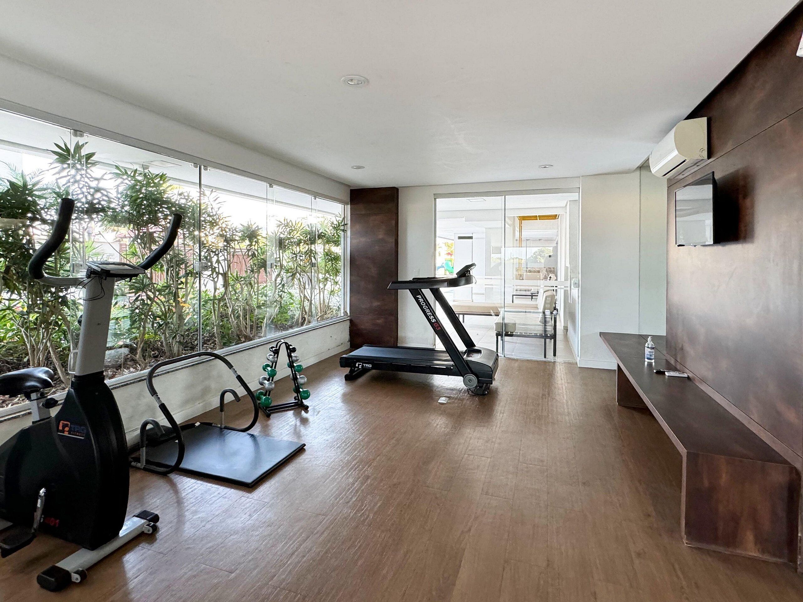 A gym with exercise equipment, a treadmill, and a weight bench.