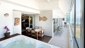 A modern interior with a dining area, a hot tub, and a view of the sea. - Cobertura com Jacuzzi em Palmas  (Governador Celso Ramos)