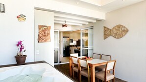 Un interior moderno con jacuzzi, comedor, cocina y obras de arte.