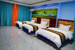 A hotel room with three beds, a large painting, and a view of a landscape. - Kuqa Xinyu Hotel (Guiz Plaza) (Kuqa)
