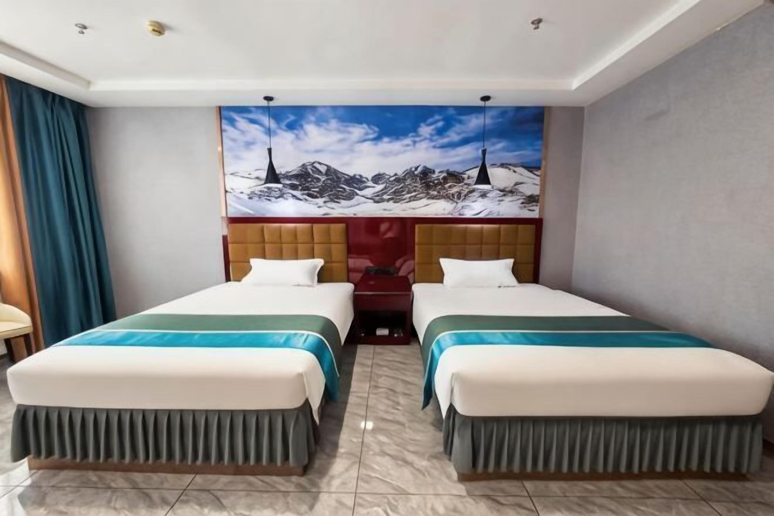 A hotel room with two beds, a large window, a mural of mountains, and a wooden headboard.