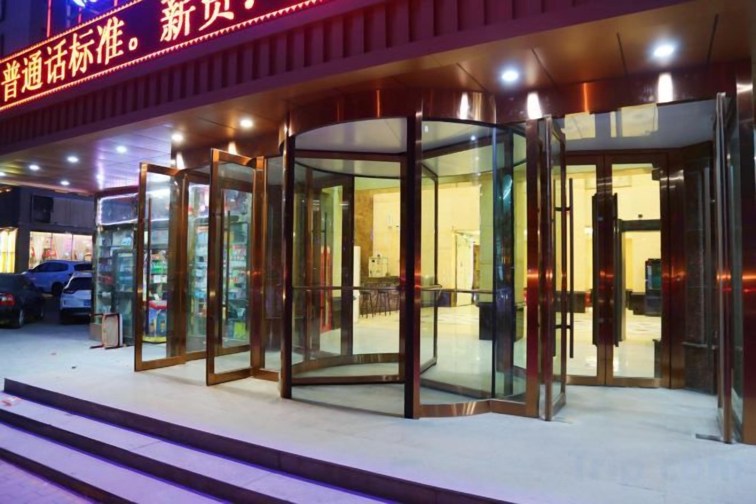 Entrada de hotel con puertas giratorias de vidrio y un letrero que indica un nuevo estándar.