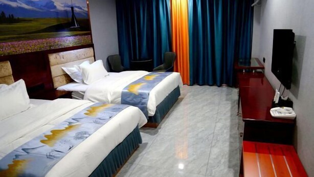 A hotel room with two beds, a desk, a chair, a TV, and a painting on the wall.