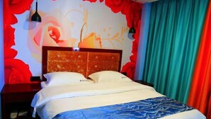 Una camera d'albergo con un letto, un comodino, un murale e delle tende.