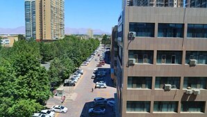 A multi-story parking lot adjacent to a building with air conditioning units.