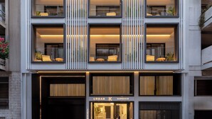 A modern multi-story building with balconies, large windows, and a ground-level entrance. - Urban-K (Athens)