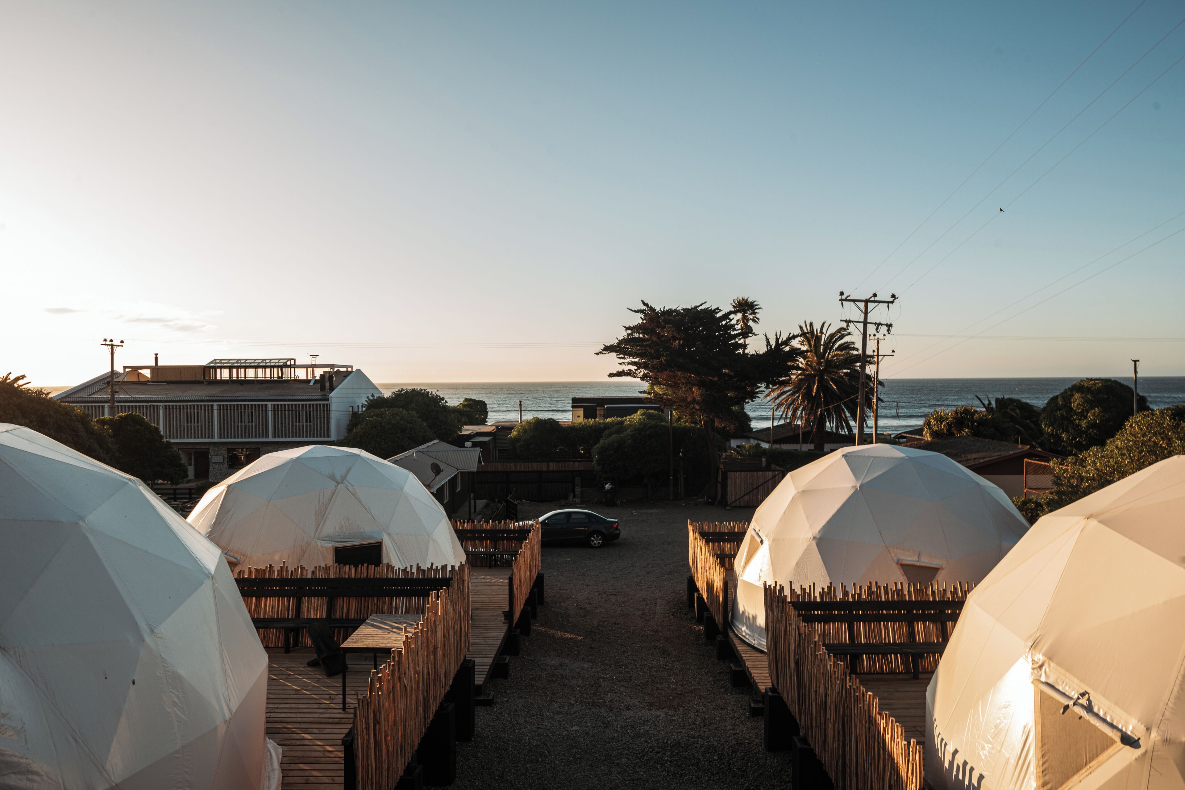 A pathway leading to dome-shaped accommodations with a view of the ocean.