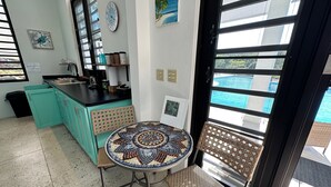 A kitchen with turquoise cabinets, a black countertop, and a tiled table. - Dragonfly Hill Private Caribbean Escape w/private pool near Buye and Boqueron (Cabo Rojo)