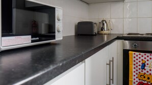 A kitchen with a microwave, toaster, and coffee maker on the counter. - Couldon Lodge  Double Room 1 (Stoke-on-Trent)