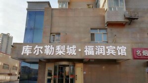 A building with a sign that reads "库尔勒梨城·福润宾馆".