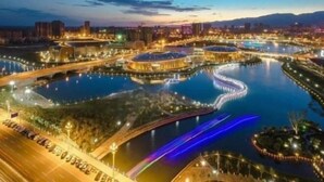 A large, illuminated water park with multiple pools and walkways.