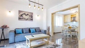 Una sala de estar moderna con un sofá, una mesa de centro y un cuadro de manos formando un corazón.