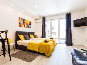A modern hotel room with two beds, a flat-screen TV, and a large window. - Spacious Two sis Apartments in Zadar With Terrace (Zadar)