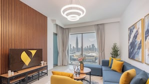 Un salon moderne avec vue sur la ville, une télévision, un canapé et une table basse.