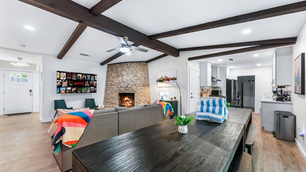 Una sala de estar moderna con chimenea, una mesa de comedor y una zona de cocina.