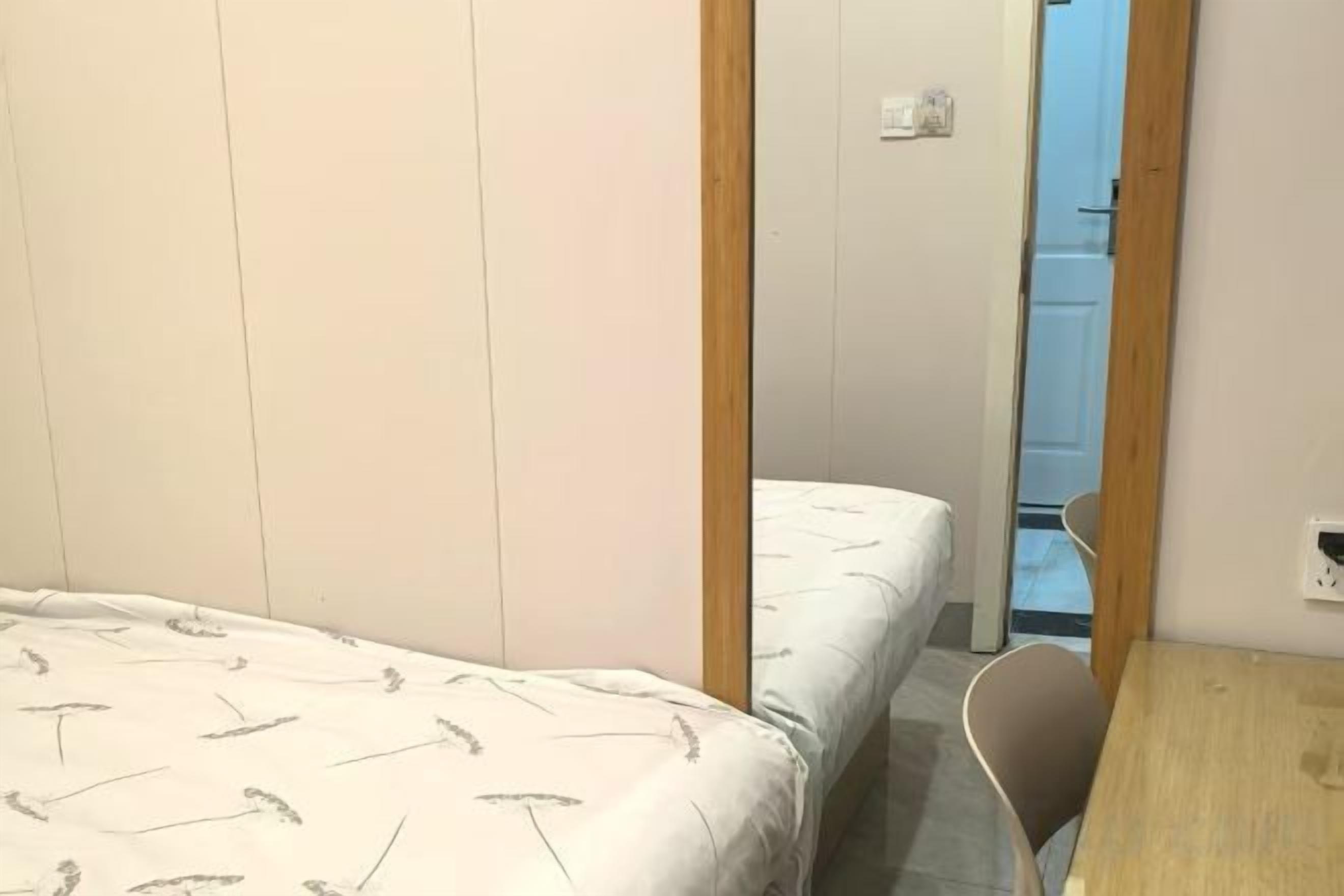 Ein Schlafzimmer mit einem Bett, einer Holztür und einem kleinen Tisch.