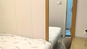 Ein Schlafzimmer mit einem Bett, einer Holztür und einem kleinen Tisch.