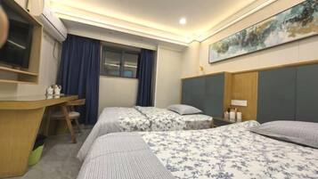 A hotel room with two beds, a desk, a chair, a TV, and a painting on the wall.