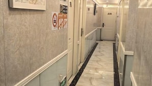 A corridor with marble flooring, doors numbered 218, and a no-smoking sign. - TongTai Preferred Hotel (Shanghai)