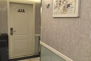 A hallway with a door labeled '219' and a framed artwork on the wall. - TongTai Preferred Hotel (Shanghai)