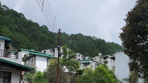 Una zona residencial con casas, una calle pavimentada y un automóvil estacionado.