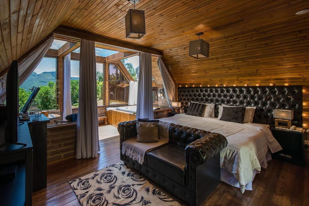 Ein Schlafzimmer mit einem großen Bett, einer Sitzecke und Blick ins Freie.
