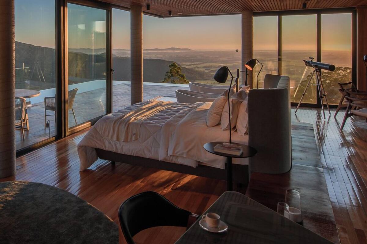 Ein modernes Schlafzimmer mit einem großen Bett, einem Schreibtisch und einem Teleskop.