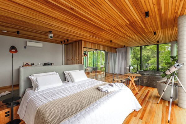 A modern bedroom with a large bed, wooden ceiling, and a telescope on a tripod. - Morada dos Canyons (Praia Grande)