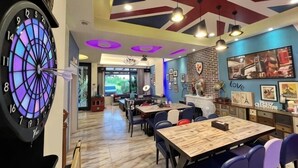 Un ristorante con un bersaglio di freccette, tavoli, sedie e vista sull'esterno.