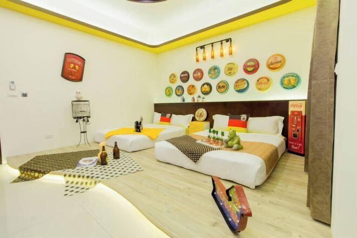 A bedroom with a bed, bedside tables, a wall clock, and a shelf with decorative plates.