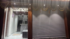 The exterior of Hotel Rudraksh with a prominent illuminated sign, a modern entrance, and a closed shutter door. - HOTEL RUDRAKSH (Rahata)