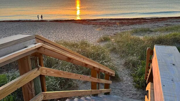 A wooden boardwalk leading to a beach with a sunset in the background. - 2 bedroom 2 Bath Home w/Pool and beach access! (Jensen Beach)