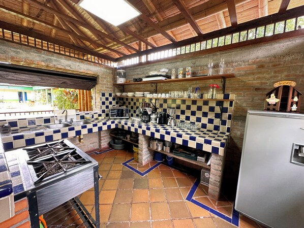 A kitchen with a checkered tile backsplash, a gas stove, and a refrigerator. - alojamiento el recuerdo (Montenegro)