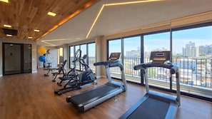 A gym with treadmills, elliptical machines, and exercise balls.