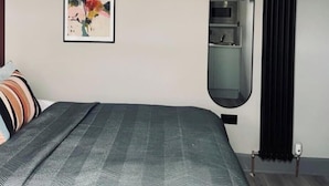 Une chambre à coucher avec un lit, un tableau encadré, un miroir intégré et un radiateur.