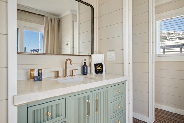 A bathroom with a sink, mirror, and green cabinets.