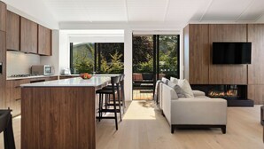 A modern kitchen with wooden cabinets, a central island, and a built-in TV.