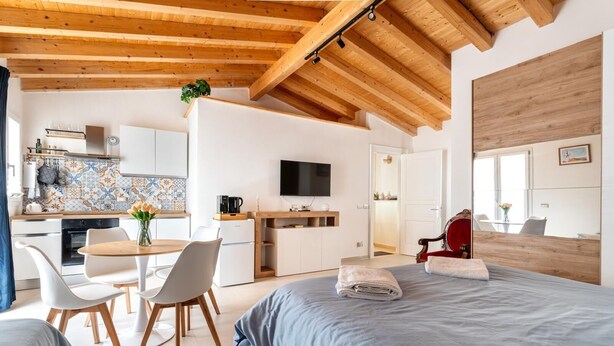 A modern hotel room with a bed, a desk, and a kitchenette. - NICA&DAMA fully equipped apartment with 5 beds (Palermo)