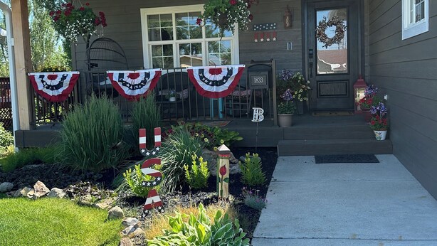 Et hus med en veranda pyntet med amerikanske flag og en postkasse med teksten "1833".
