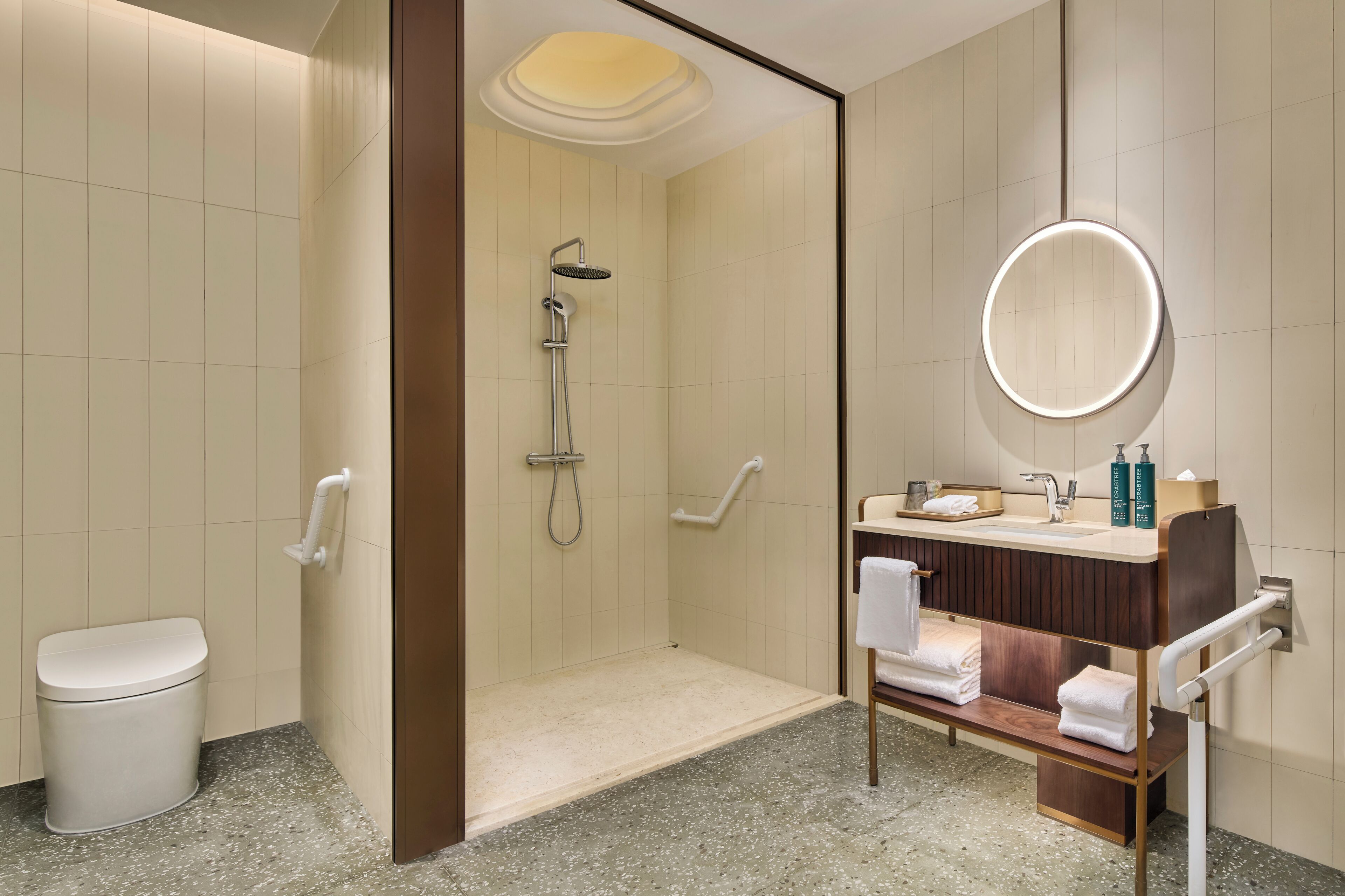 A modern bathroom with a shower, toilet, and vanity with a mirror.