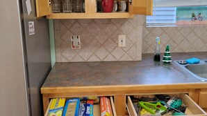 Una cocina con armarios de madera, un refrigerador de acero inoxidable y una encimera con vista al exterior.