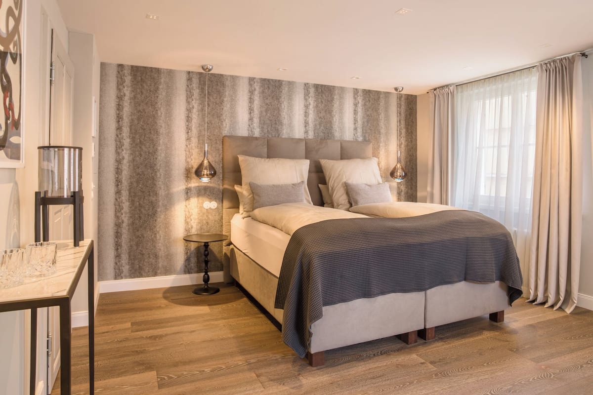 Un dormitorio moderno con una cama grande, una mesita de noche y una lámpara.
