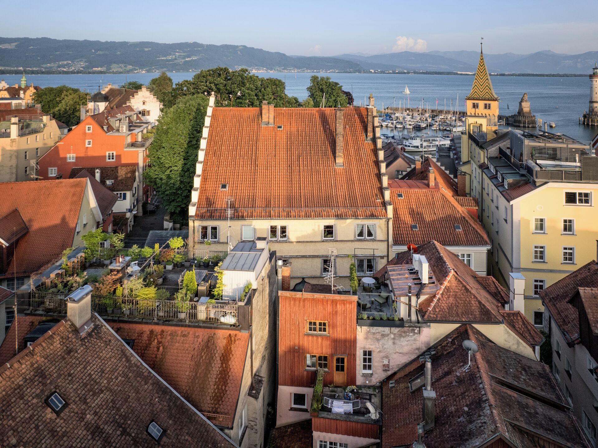 A coastal town with traditional architecture, including a prominent building with a red-tiled roof and a tower with a pointed roof.