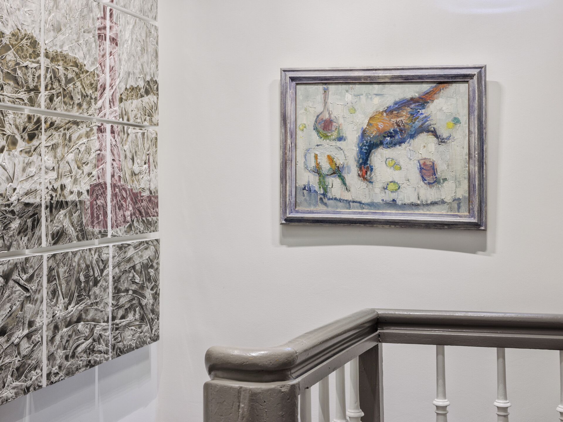 A staircase with a handrail and a wall with a framed abstract painting.