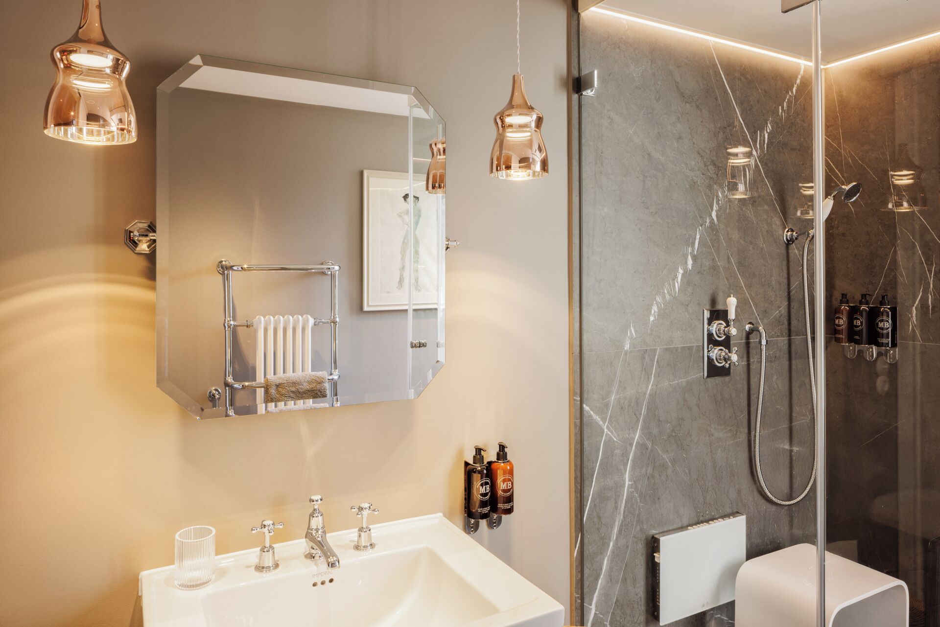 A modern bathroom with a large mirror, a white sink, and a glass shower enclosure.