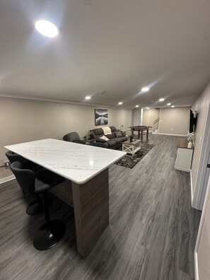 A modern kitchen with a marble countertop and black bar stools. - Charming 3 Bedroom 2.5 Bathroom House centrally located in Dubuque IA. (Dubuque)