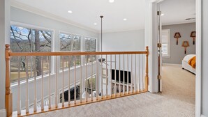 Ein geräumiges Zimmer mit großem Fenster, einer Treppe und einem Bett.