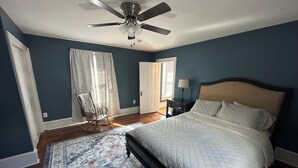 A bedroom with a bed, a ceiling fan, a chair, a nightstand, and a window with curtains. - Newly renovated 3 bed 2 bath house in Clifton Forge, Va (Clifton Forge)