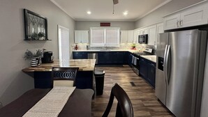 A modern kitchen with a central island, stainless steel appliances, and a ceiling fan. - Newly renovated 3 bed 2 bath house in Clifton Forge, Va (Clifton Forge)