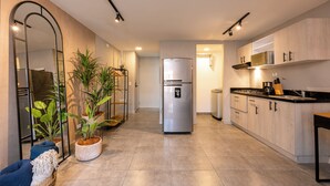 A modern kitchen with a central island, built-in appliances, and potted plants. - Tranvia 40 (Medellín)